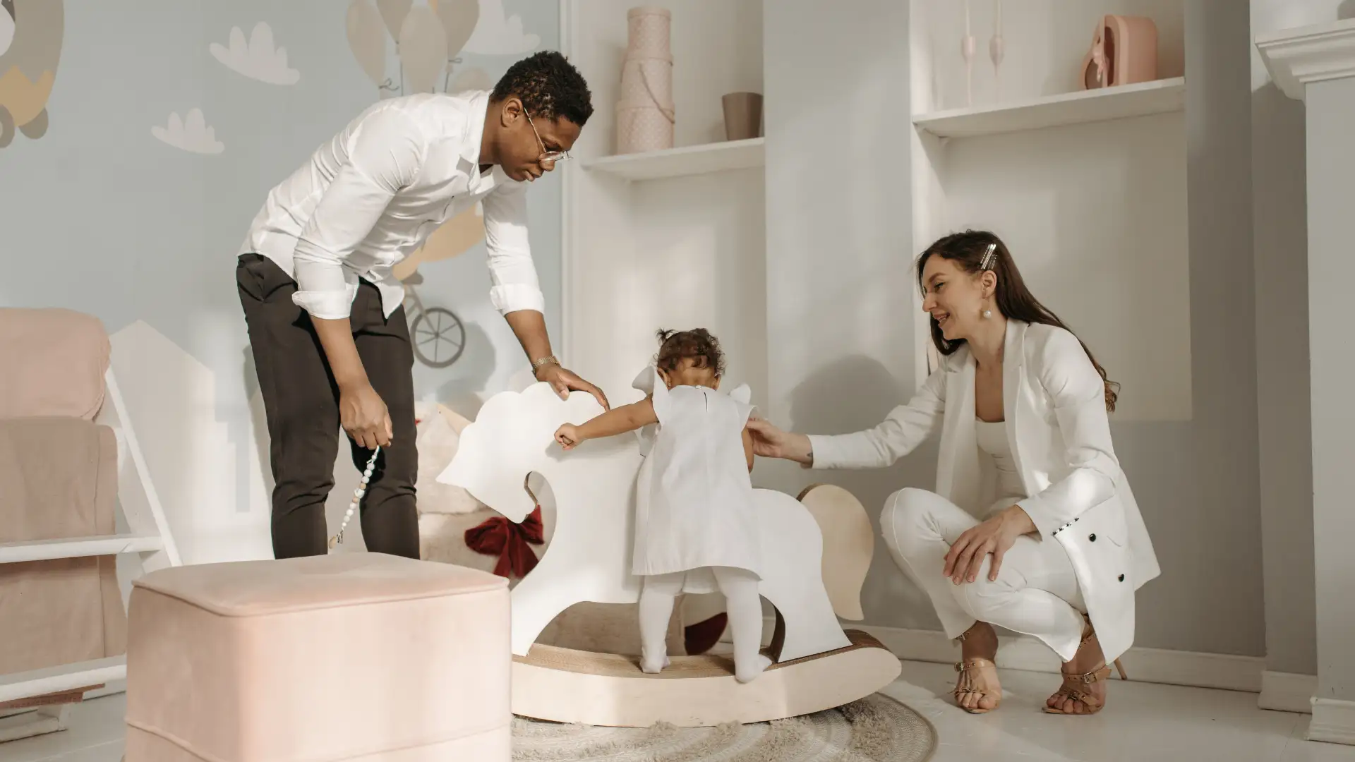 Parents helping their child on a rocking horse